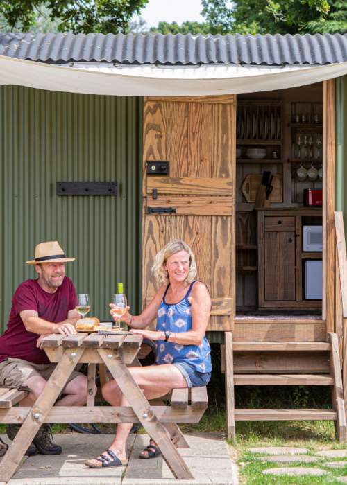 Couple glamping in shepherds hut at Red Shoot Camping Park in the New Forest